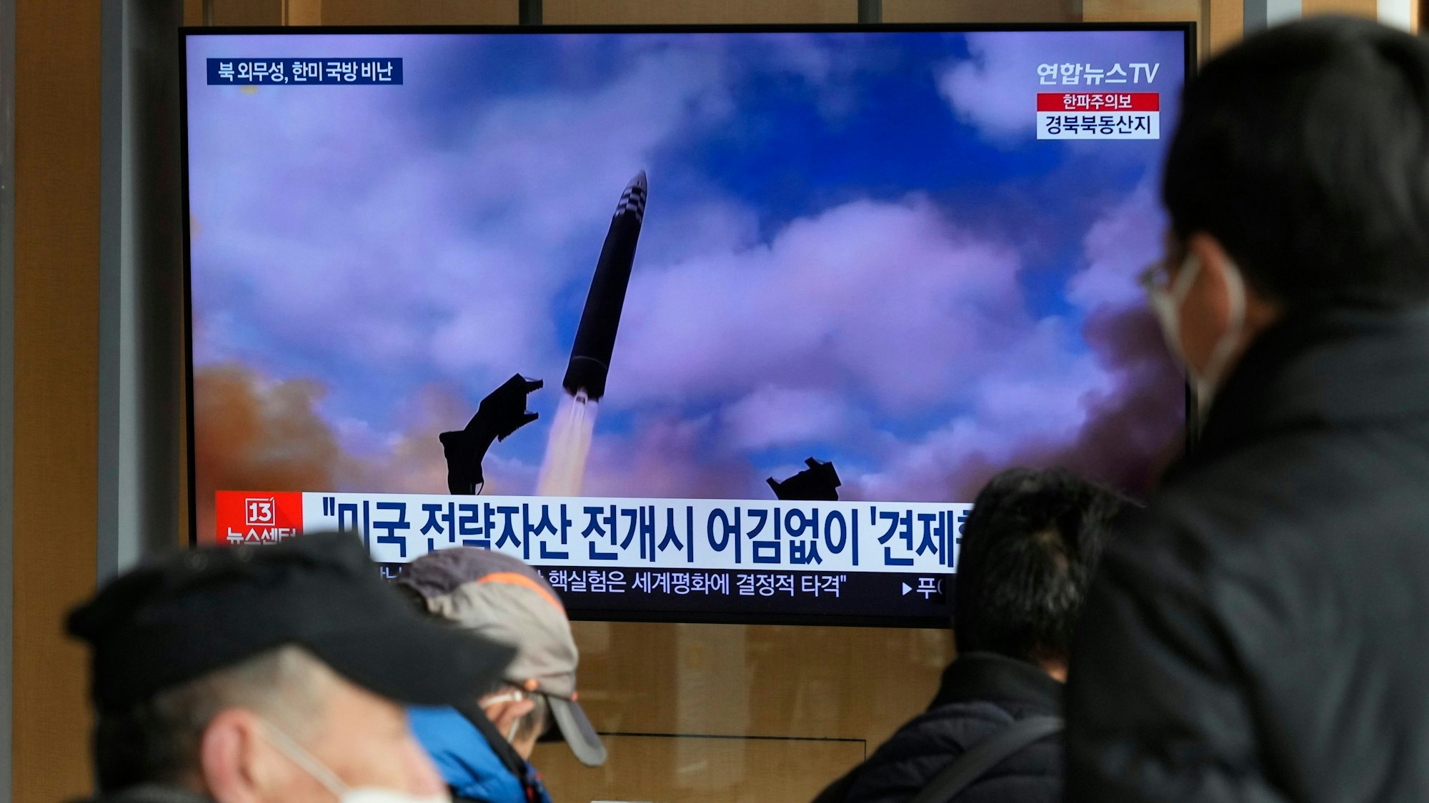 Eine Nachrichtensendung zeigt ein Archivbild eines Raketenstarts in Nordkorea in einem Beitrag der im Bahnhof ausgestrahlt wird.