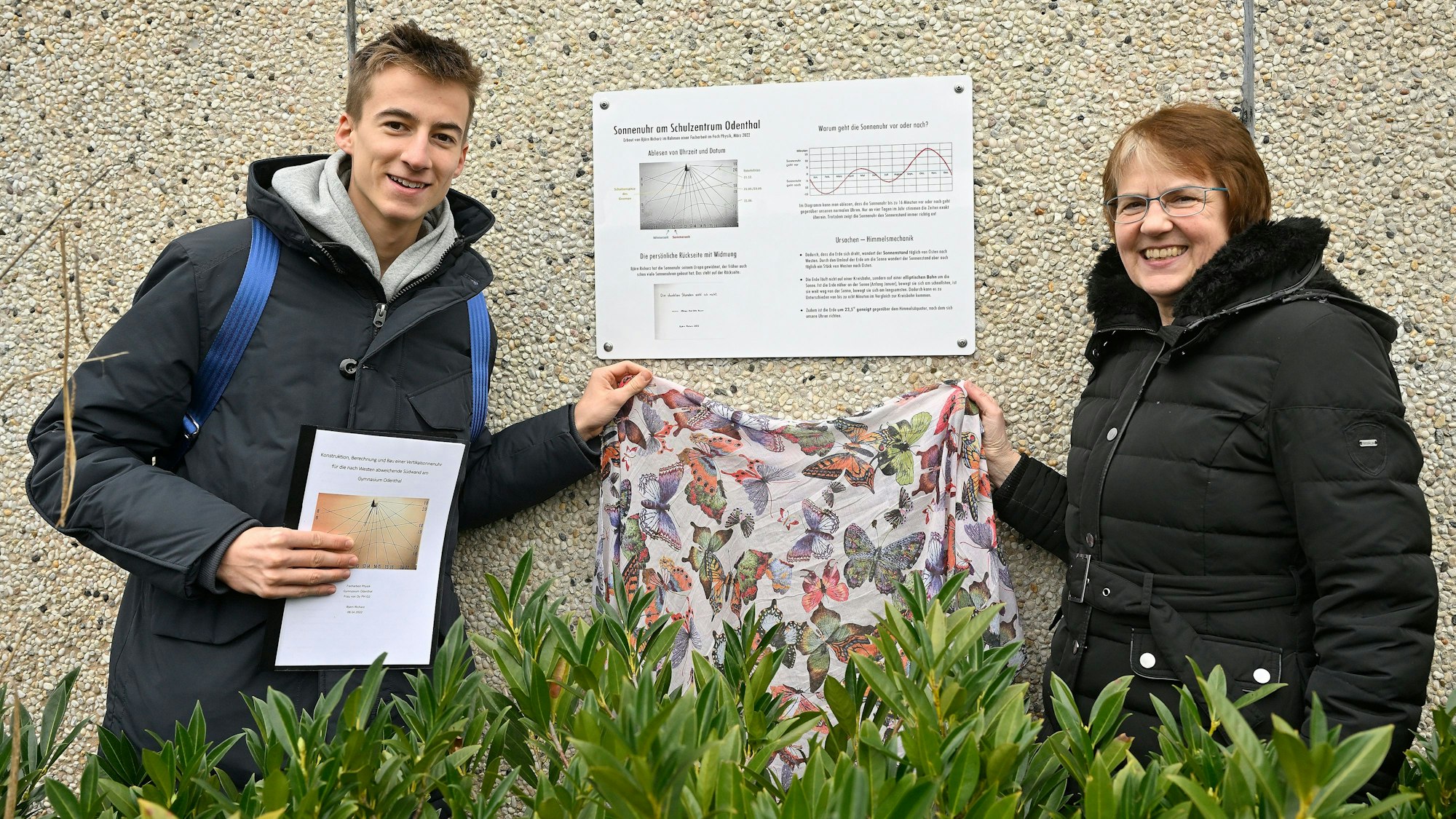 Der Schüler und die Lehrer haben eine Tafel für die Sonnenuhr enthüllt.