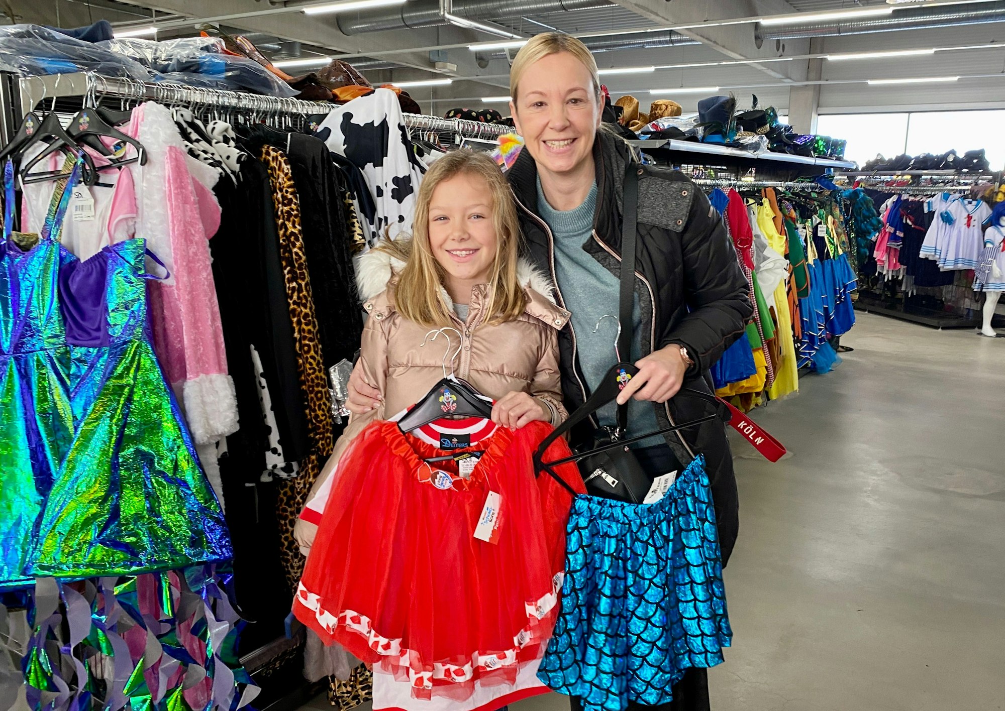 Mutter und Tochter zeigen zusammen Röcke in einem Verkleidungsgeschäft