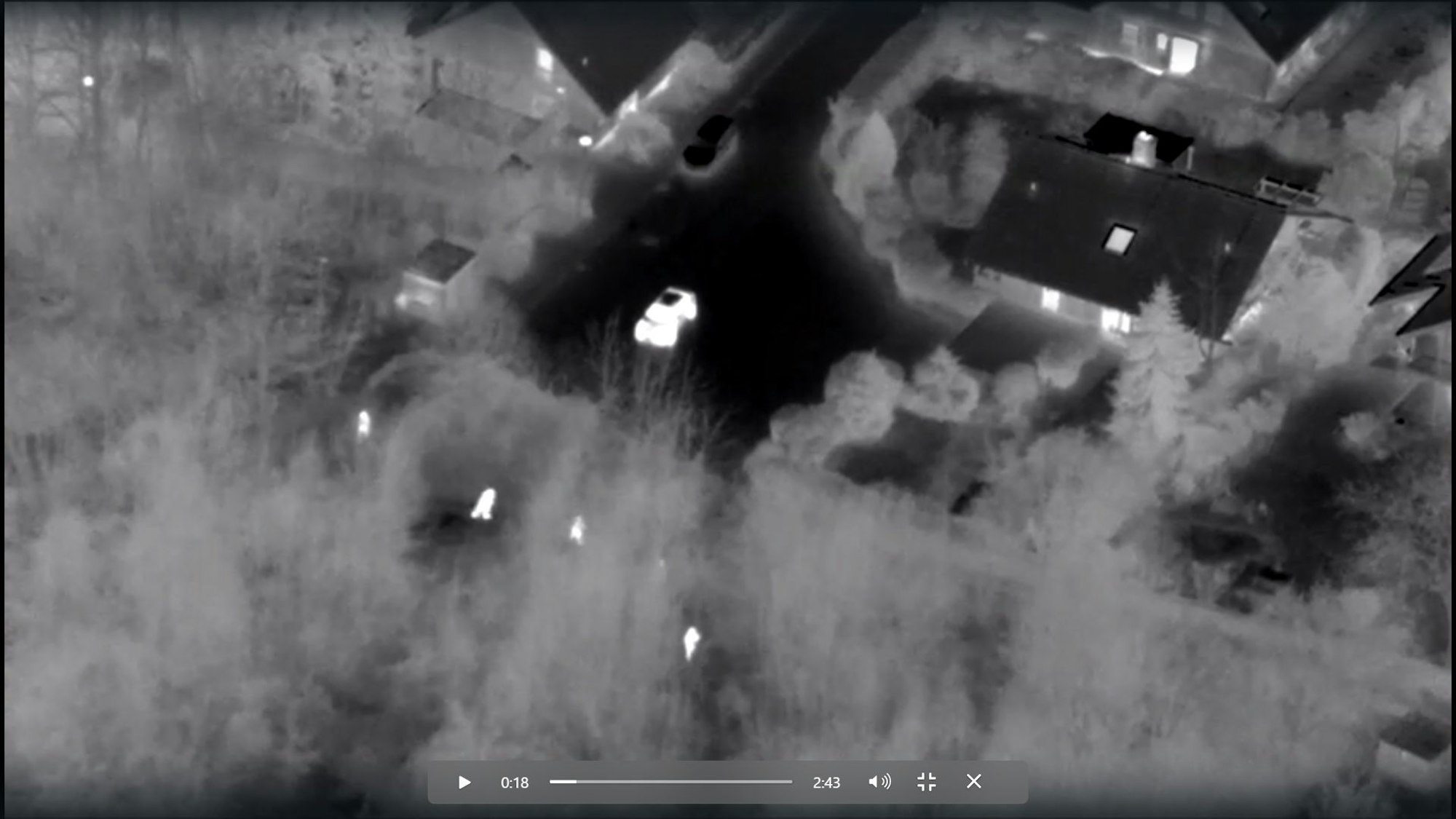 In einer Schwarz-Weiß-Darstellung sind helle Menschen vor grauem Grund zu sehen, außerdem Häuser, eine Sackgasse und ein Auto.