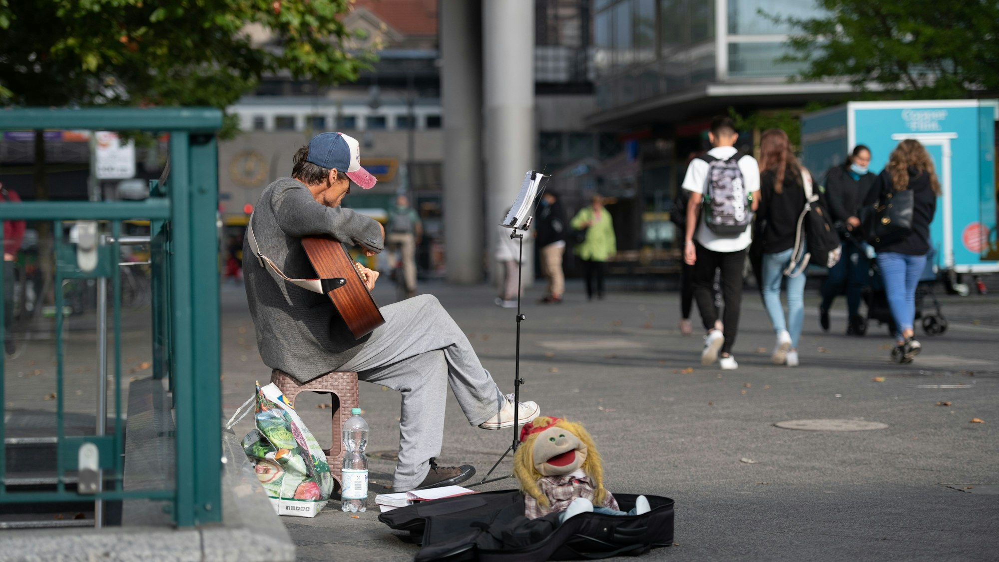 Die Stadt Bergisch Gladbach hat Verstärker für Straßenmusiker verboten. Ein Straßenmusiker sitzt mit Gitarre in einer Fußgängerzone.