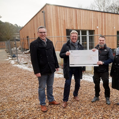 Mitglieder des Rotary-Club Euskirchen-Burgfey, Kindergartenleitung und der Bürgermeister stehen vor dem neuen Gebäude im Waldkindergarten.