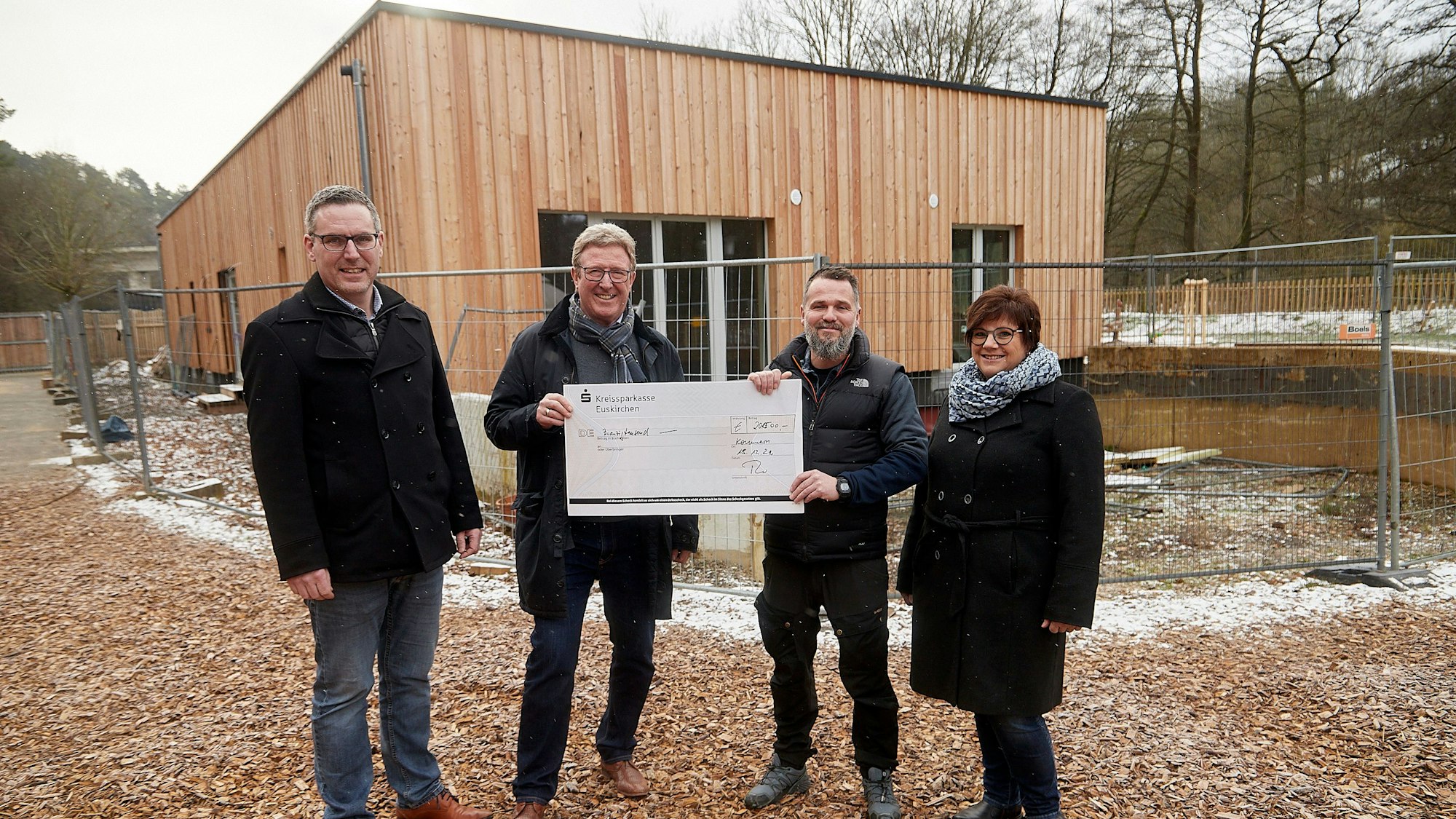 Mitglieder des Rotary-Club Euskirchen-Burgfey, Kindergartenleitung und der Bürgermeister stehen vor dem neuen Gebäude im Waldkindergarten.