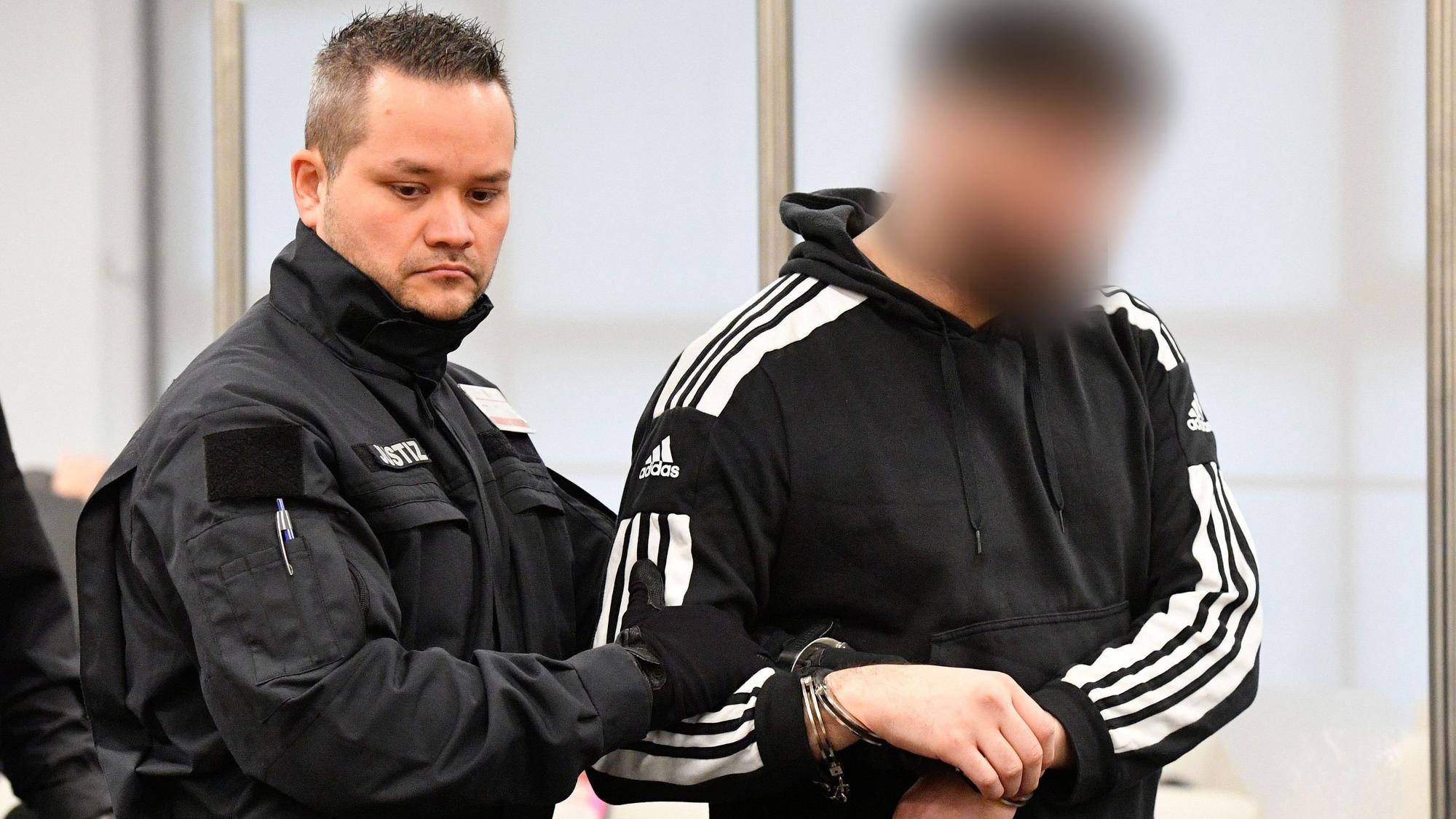 Ein Justizbeamter bringt einen Angeklagten in Handschellen in den Gerichtssaal, bevor der Prozess um einen Juwelenraub im Grünen Gewölbe des Dresdner Residenzschlosses fortgesetzt wird.