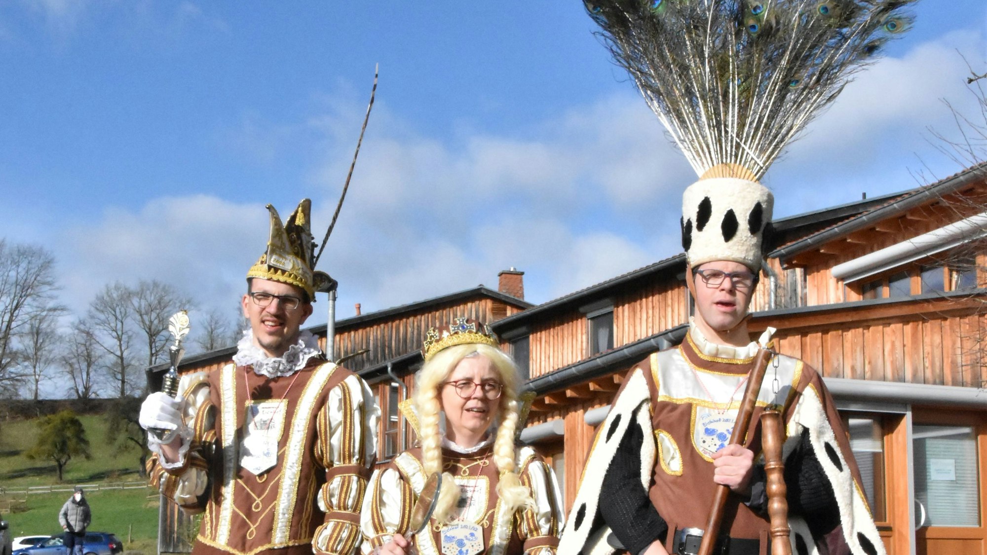 Drei Personen stehen im Totllitäten-Outfit im Freien.