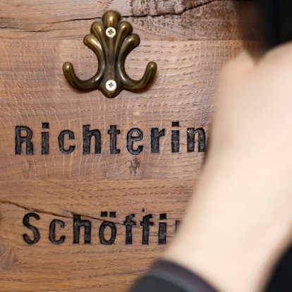 Ein Richter hängt seine Robe  an eine Garderobe für Richter und Schöffen