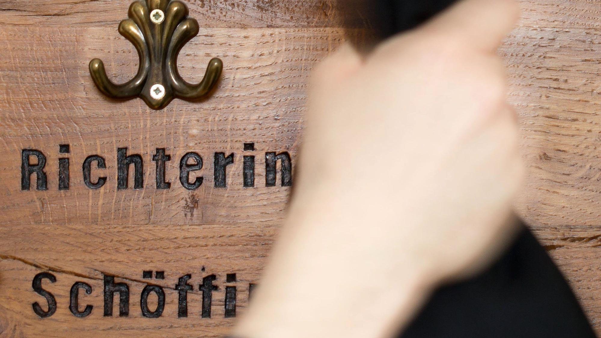 Ein Richter hängt seine Robe an eine Garderobe für Richter und Schöffen