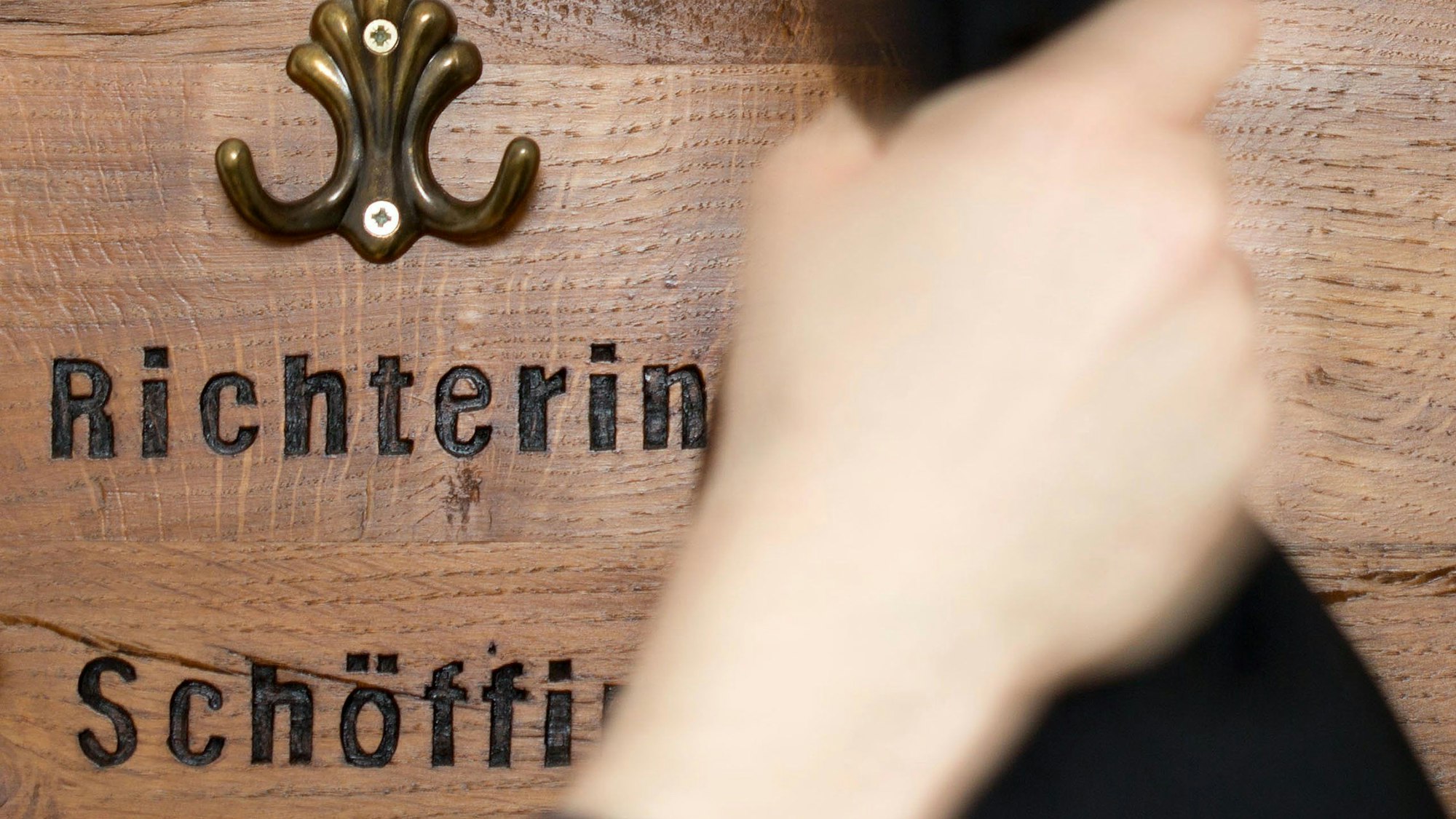 Ein Richter hängt seine Robe am im an eine Garderobe für Richter und Schöffen.