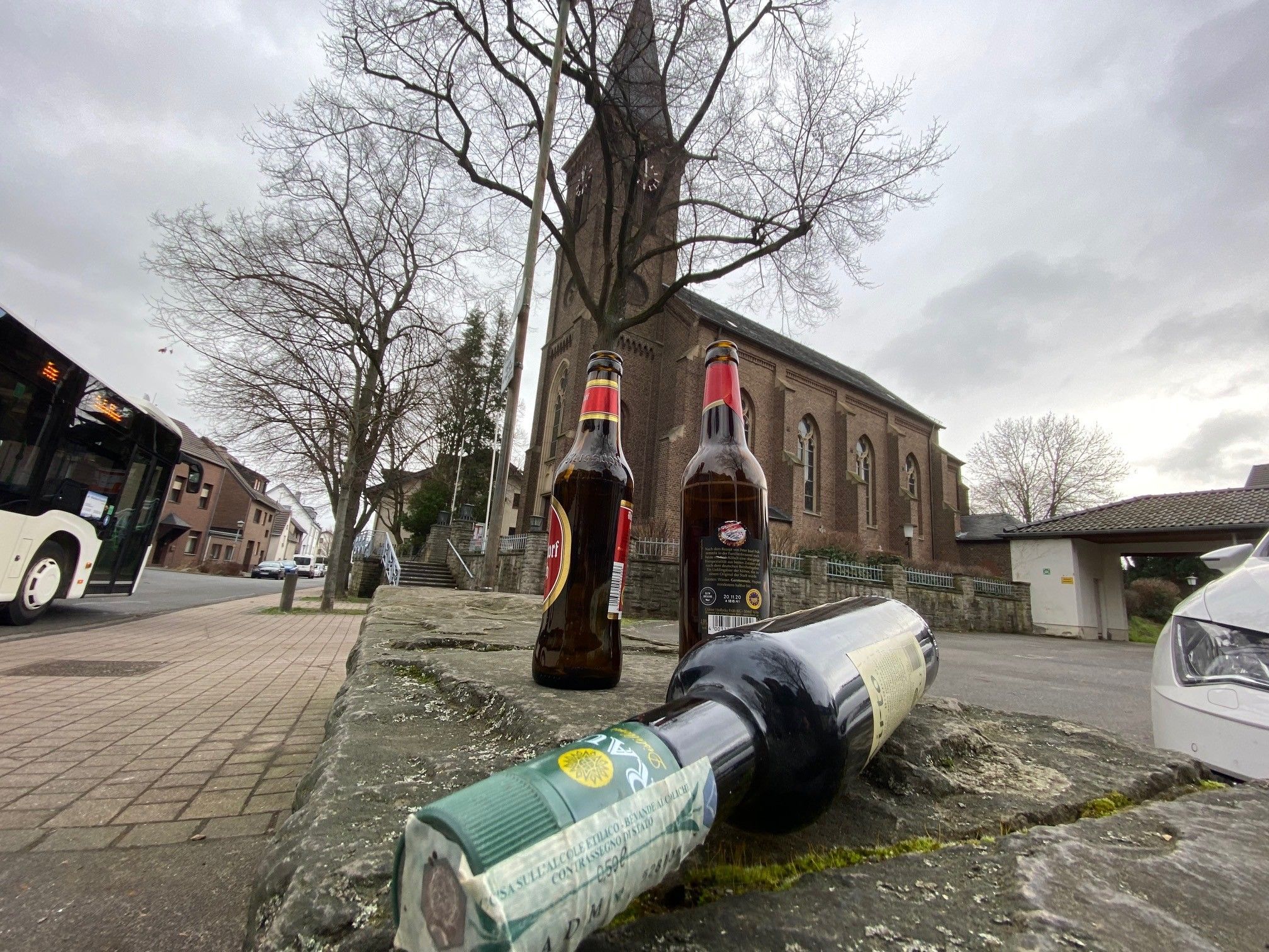 Vor der Kirche in Brühl-Schwadorf liegen Glasflaschen. Das Foto haben wir gestellt.