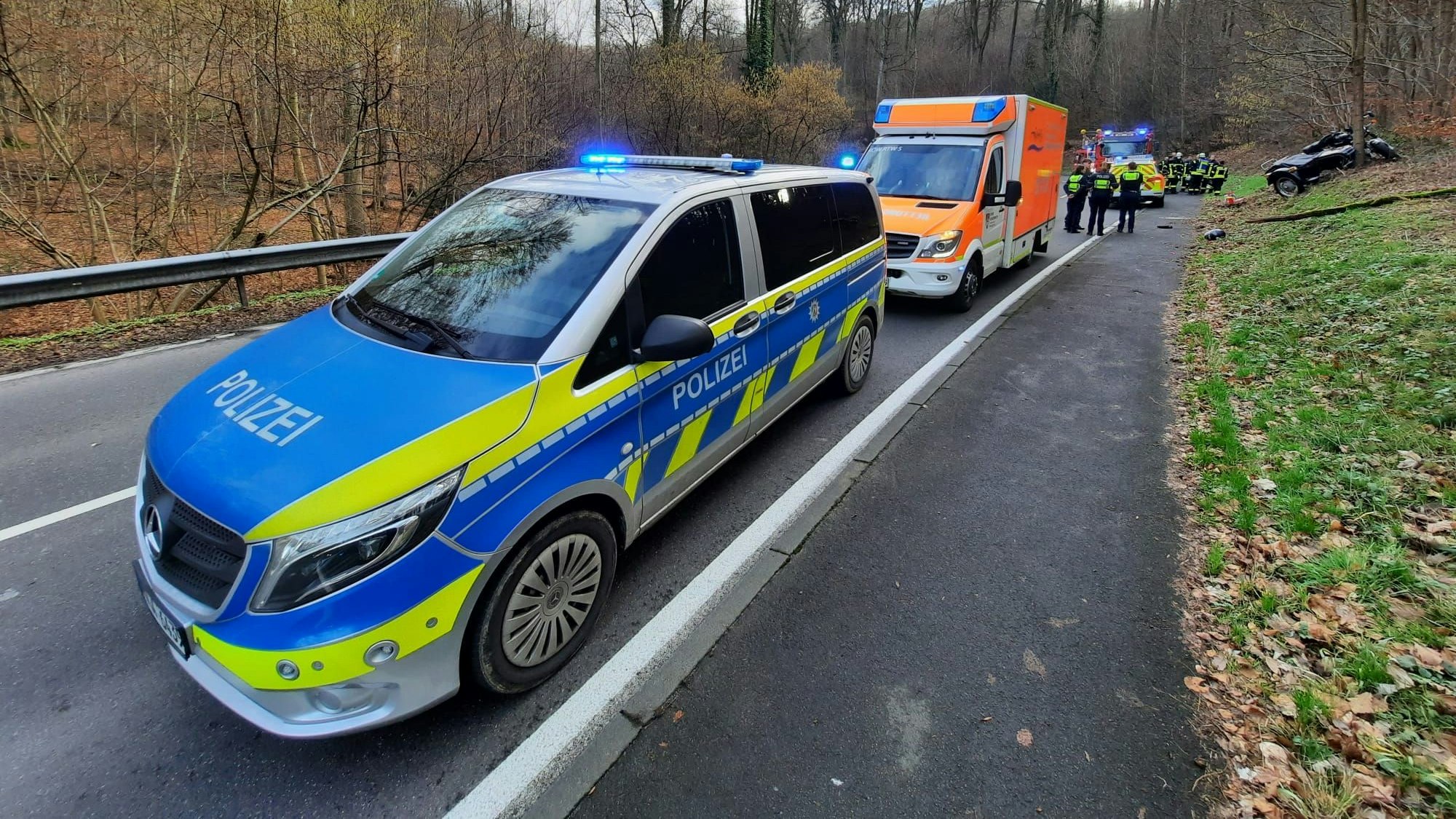 Man sieht ein Polizeiauto, dahinter Krankenwagen und Feuerwehrwagen.