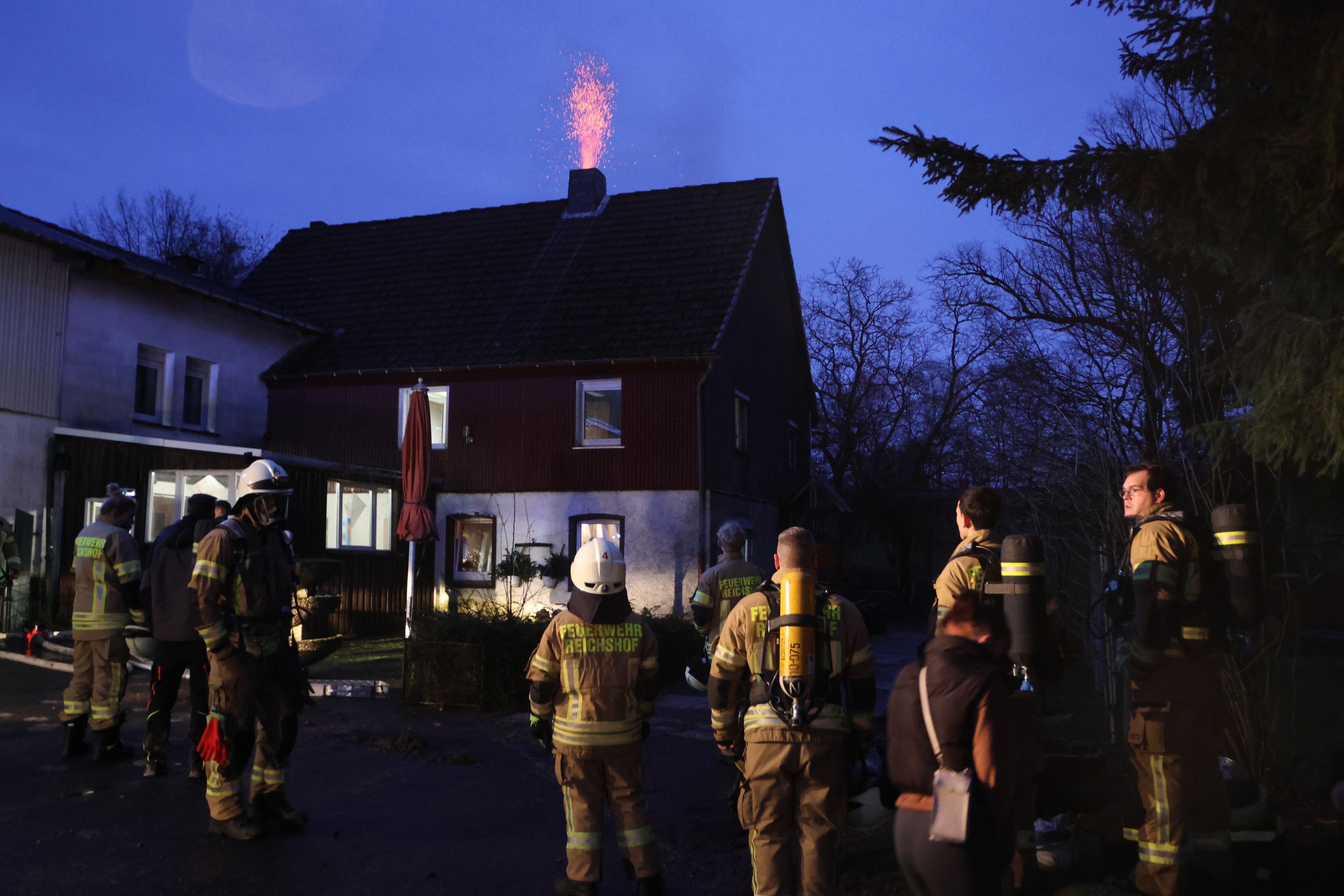 Einsatzkräfte der Freiwilligen Feuerwehr Reichshof stehen am späten  Freitagnachmittag am Einsatzort.