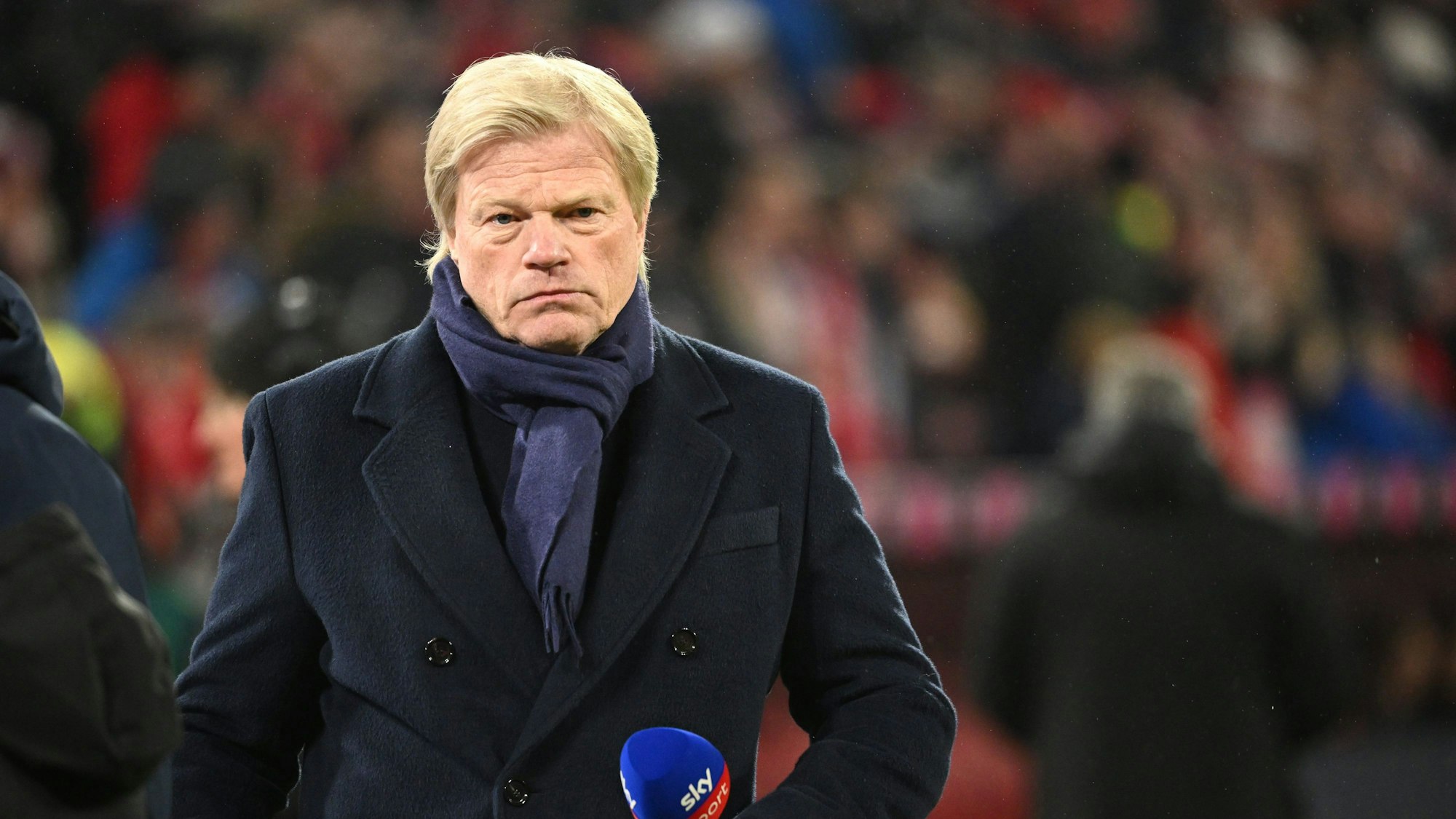 Oliver Kahn hält ein Mikrofon in der Hand.