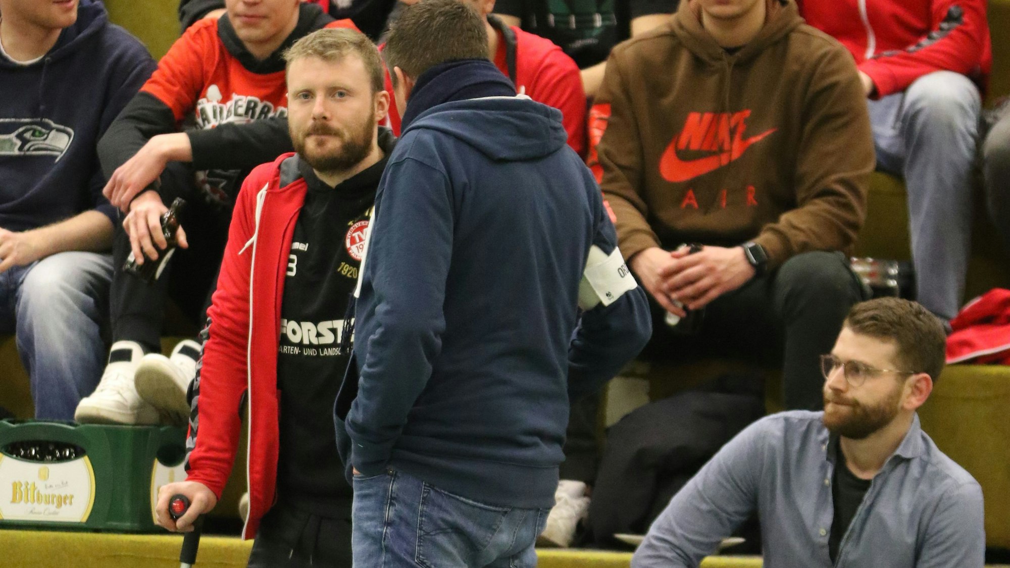 René Lönenbach steht mit Krücken am Spielfeldrand.