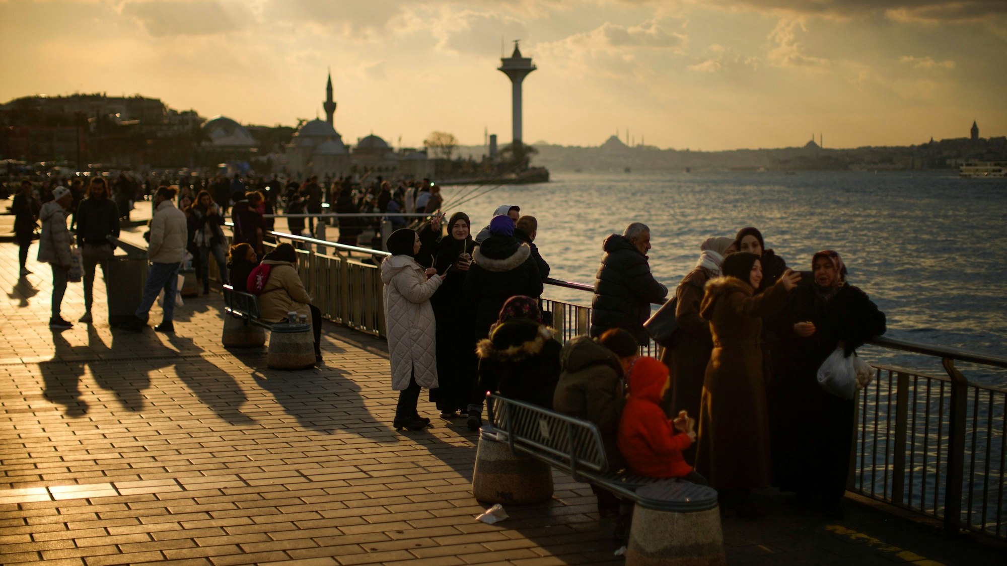Türkei, Istanbul: Menschen sitzen und fotografieren an der Uferpromenade Üsküdar am Bosporus.