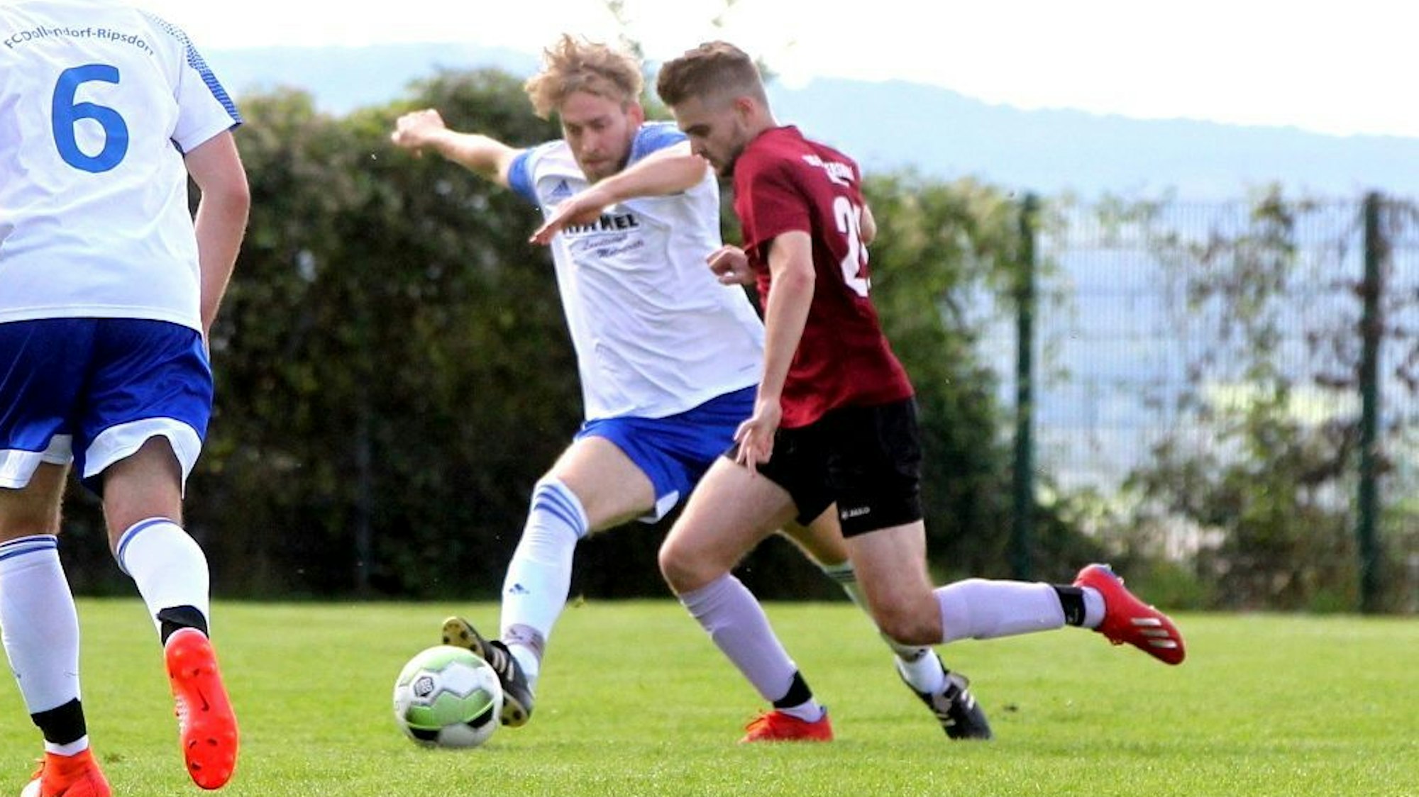 Fußballer Paul Doppelfeld (rotes Trikot) setzt sich gegen einen Gegner durch.