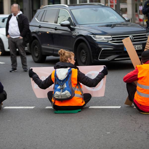 Klimaaktivisten kleben sich auf der Straße in Köln am Neumarkt fest.