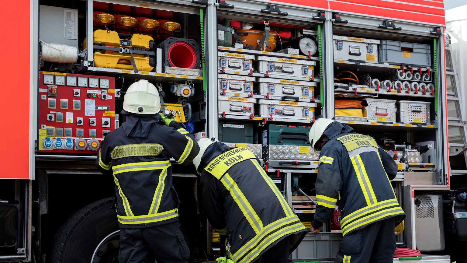 Feuerwehrleute stehen an einem Feuerwehrauto