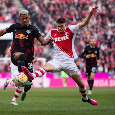 Leipzigs Benjamin Henrichs (l) und Kölns Eric Martel kämpfen um den Ball.