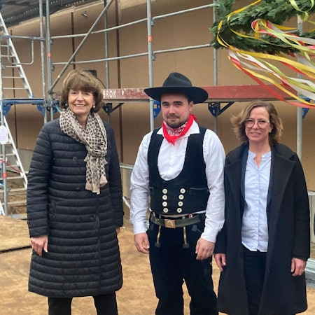 Zwei Frauen und zwei Männer steher vor dem Schulgebäude