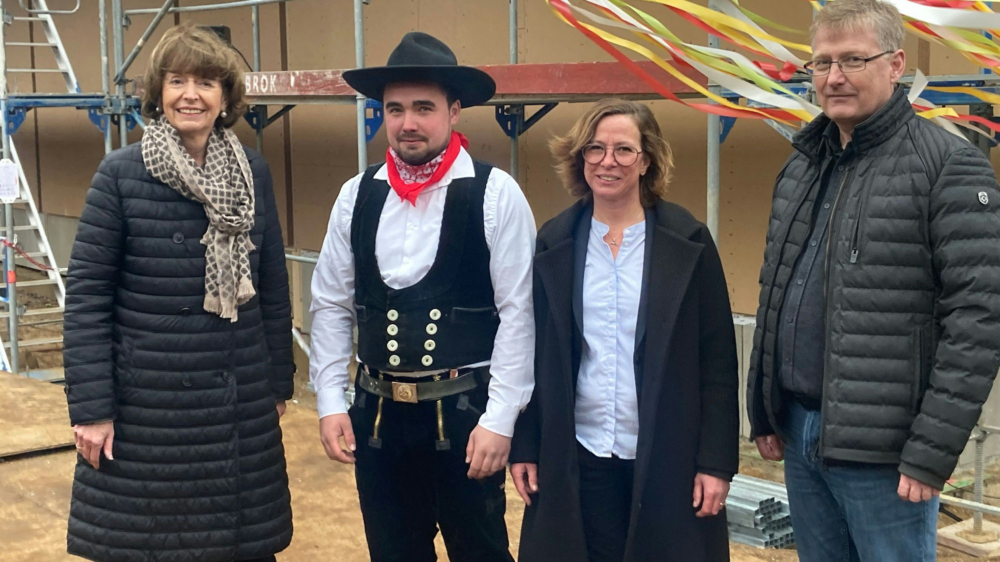 Zwei Frauen und zwei Männer steher vor dem Schulgebäude