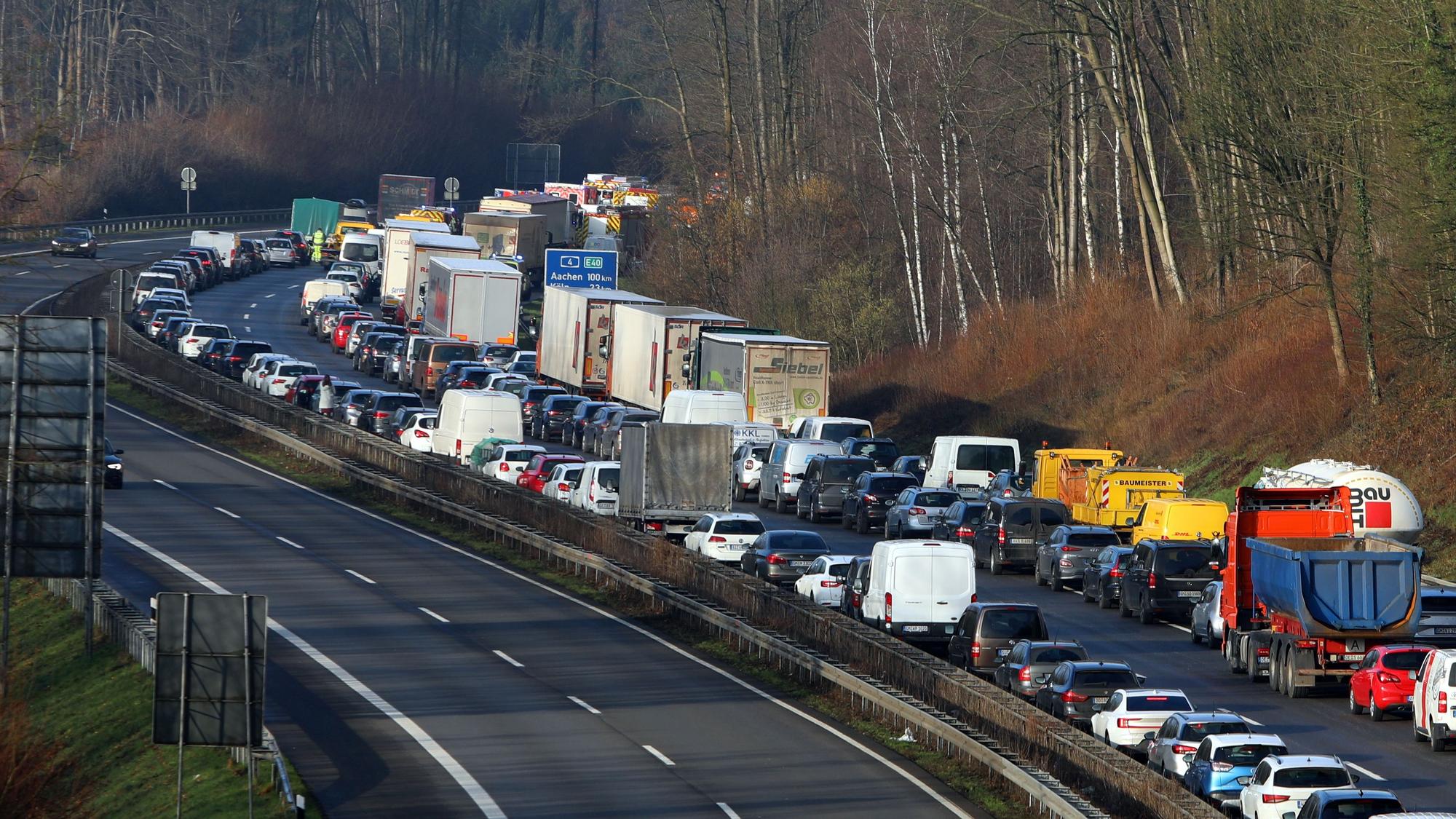 Autos stauen sich auf der Autobahn. Am Anfang des Staus sind in der Ferne Feuerwehrfahrzeuge zu erkennen.