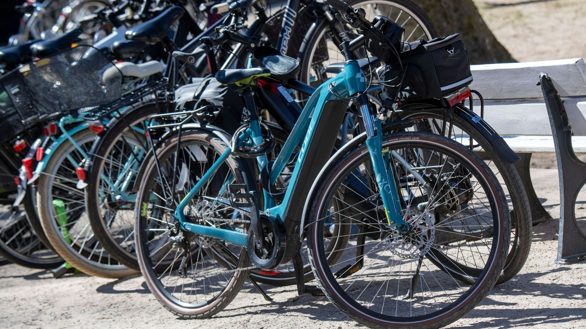 Elektroräder stehen in einem Ständer, ein blaues steht davor.