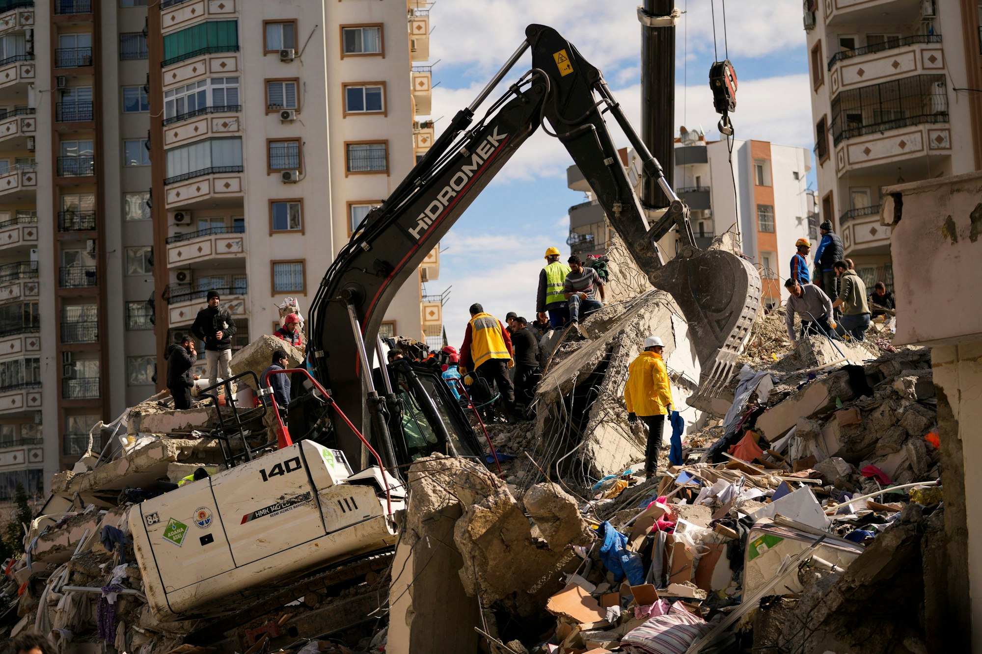 07.02.2023, Türkei, Adana: Mitglieder eines Rettungsteams suchen nach Menschen in einem zerstörten Gebäude.
