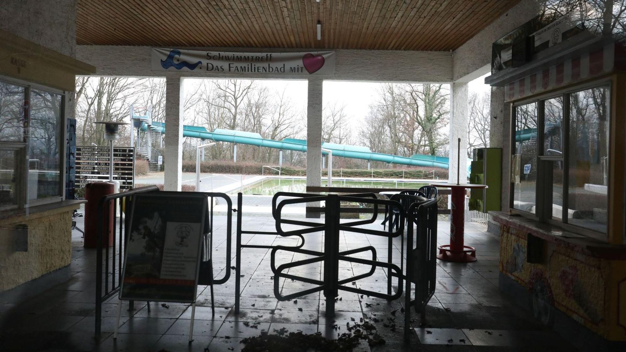 Laub liegt vor dem Drehkreuz im Eingangsbereich des Lemmerz-Freibades. Das „Familienbad“ steht auf einem Banner an der Decke.Im Hintergrund ist die große Rutsche zu sehen.