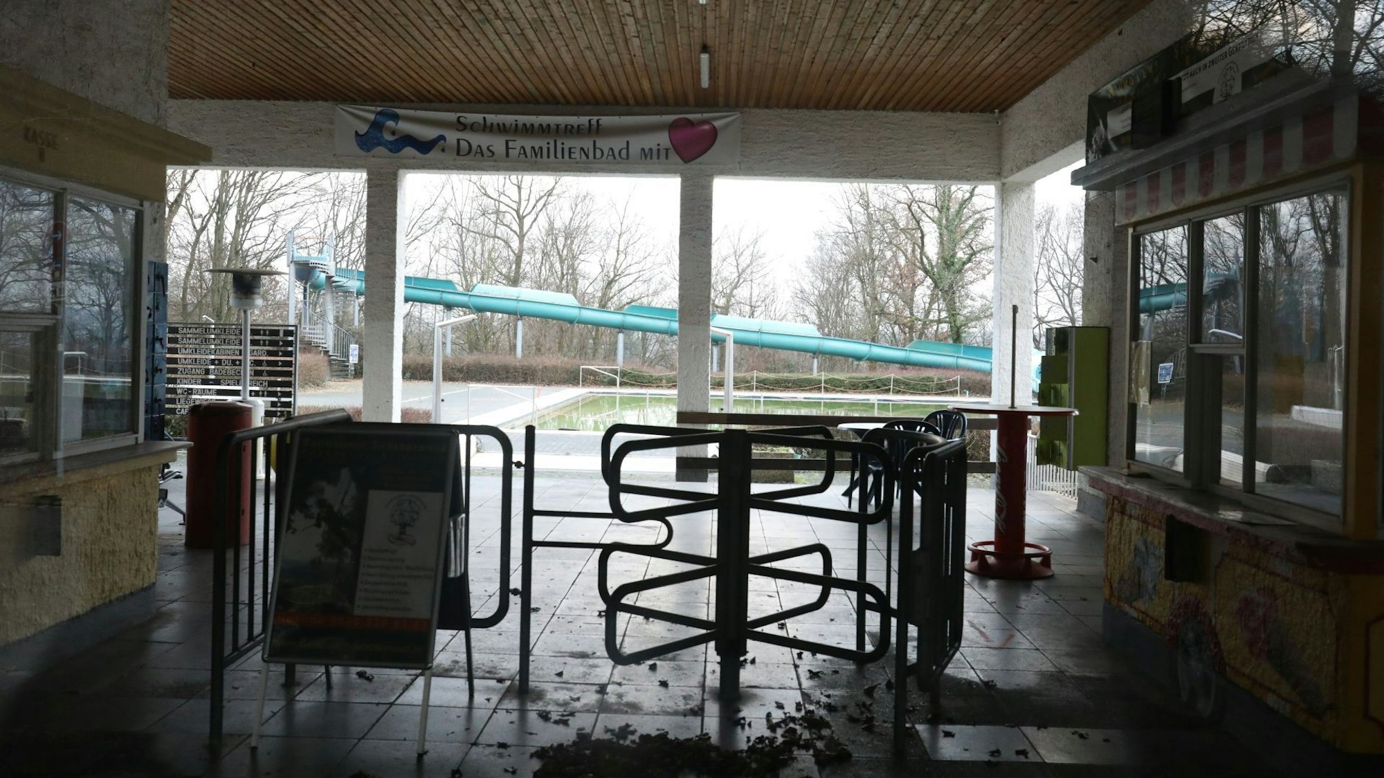 Laub liegt vor dem Drehkreuz im Eingangsbereich des Lemmerz-Freibades. Das „Familienbad“ steht auf einem Banner an der Decke.Im Hintergrund ist die große Rutsche zu sehen.