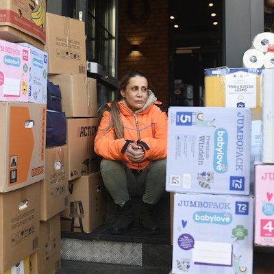 Selver Bicilir sitzt zwischen zahlreichen Spenden für die Erdbebenregion in der Türkei und in Syrien.