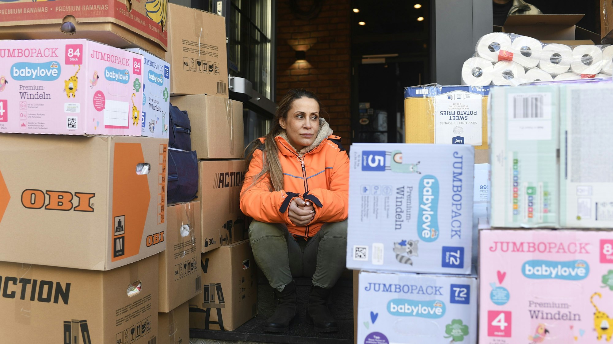 Selver Bicilir sitzt zwischen zahlreichen Spenden für die Erdbebenregion in der Türkei und in Syrien.