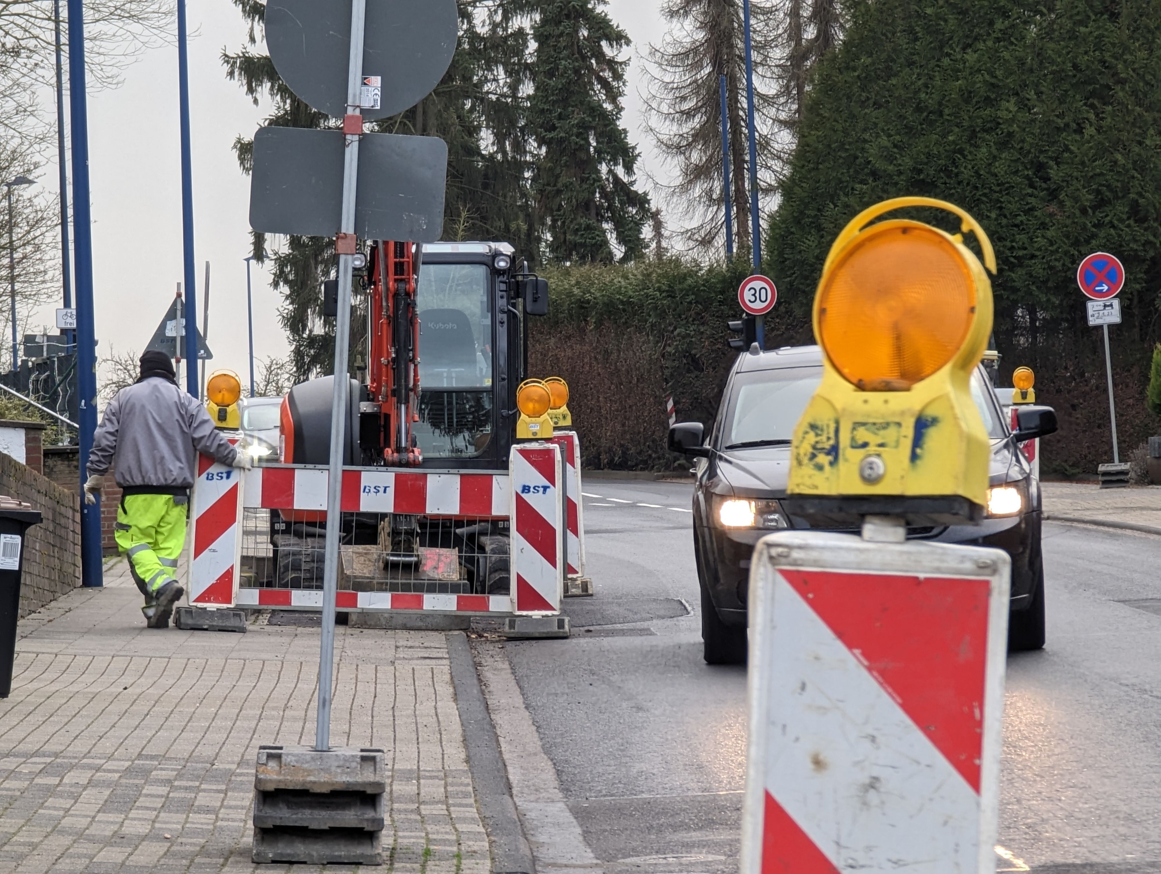 Man sieht eine Straße, auf der Baustellenabsperrungen einseitig die Fahrbahn verengen.