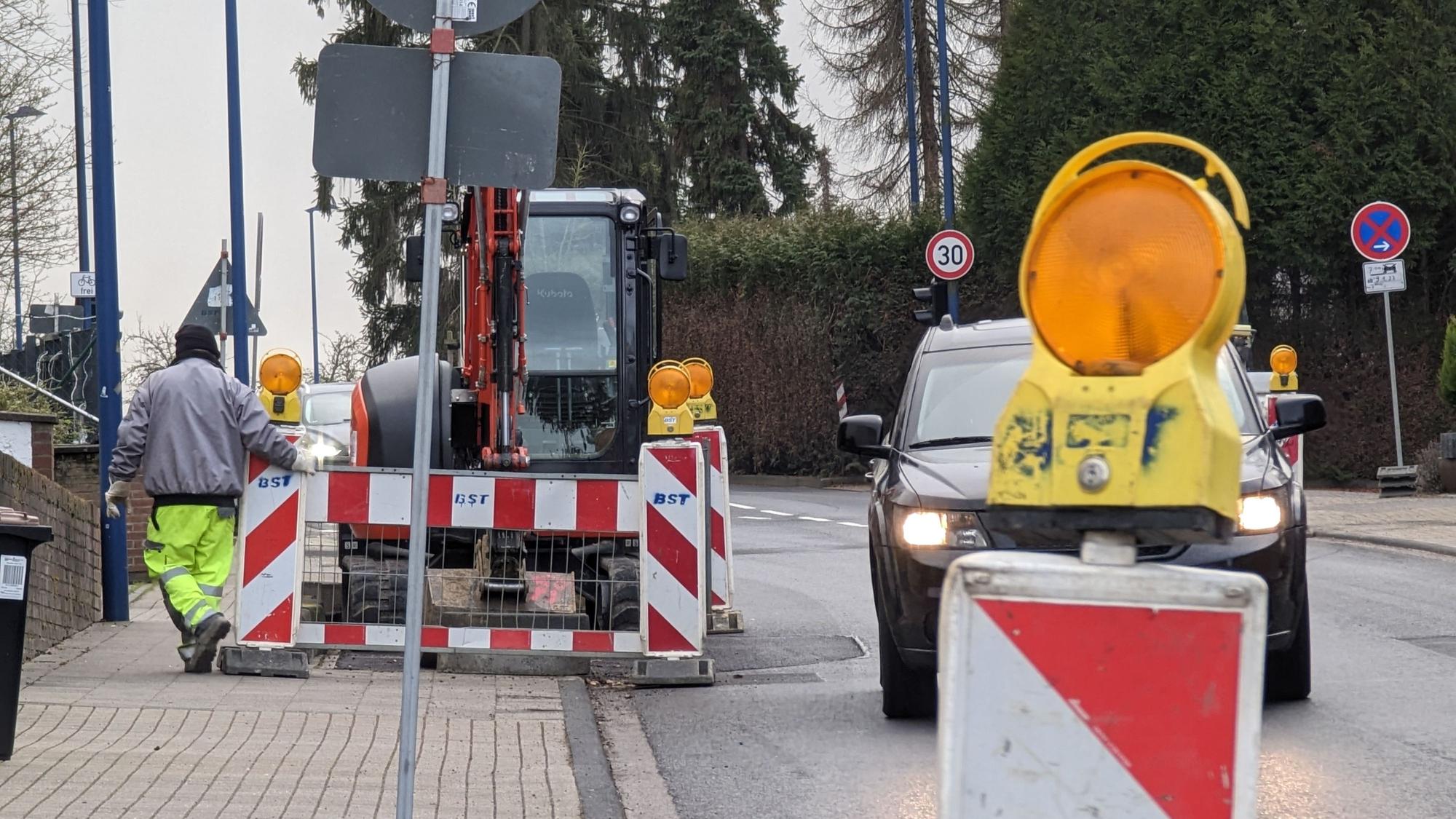 Man sieht eine Straße, auf der Baustellenabsperrungen einseitig die Fahrbahn verengen.