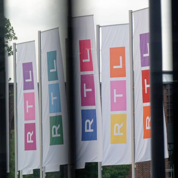 Fahnen des Fernsehsenders RTL stehen auf dem Platz vor dem Firmengebäude.