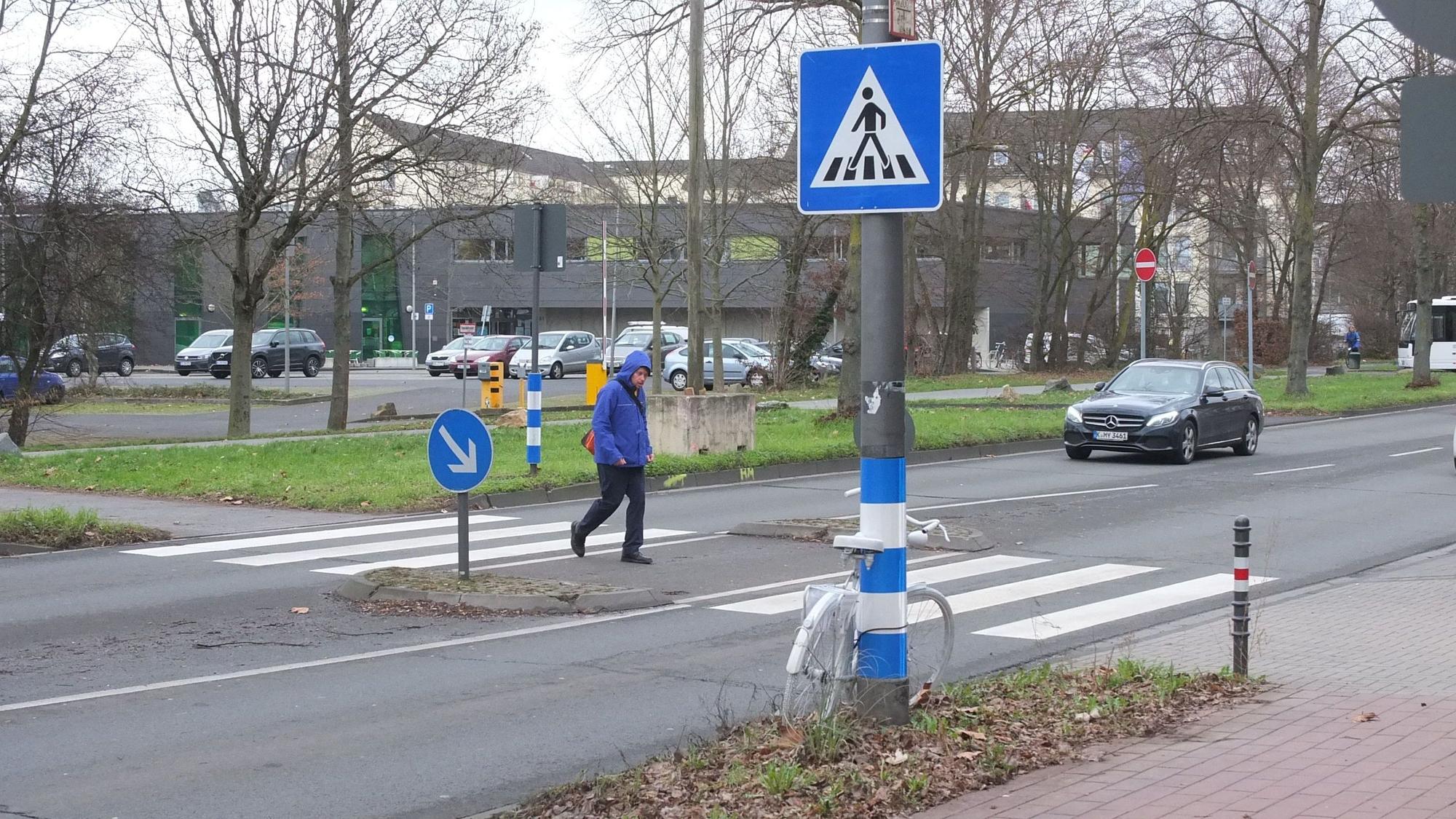 Der Zebrastreifen auf der Äußeren Kanalstraße mit einem Fußgänger und Auto.