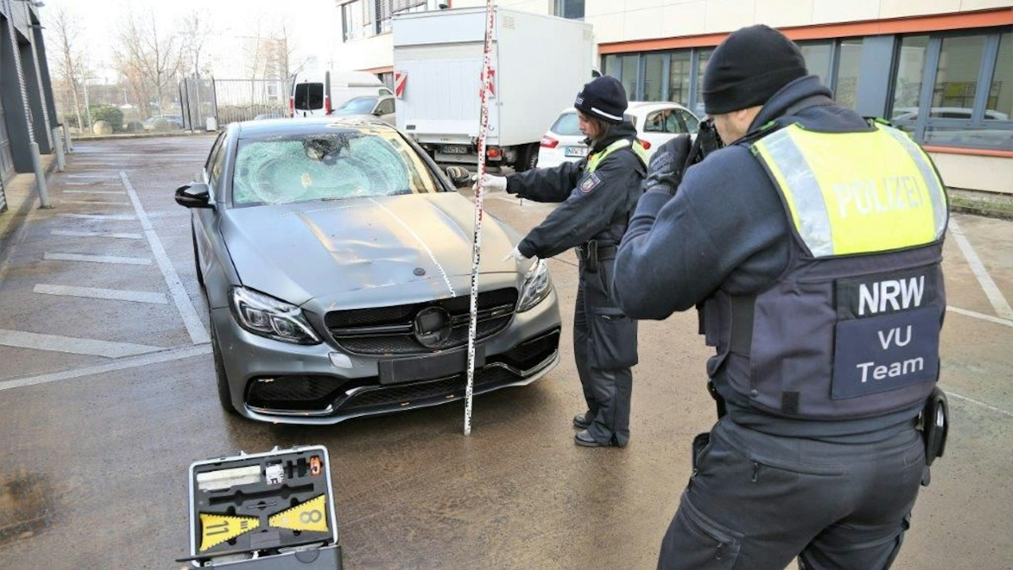 Nach der Sicherstellung des Mercedes untersuchten Polizisten den Unfallwagen.