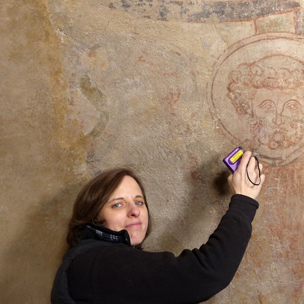 Die Kölner Diplom-Restauratorin Birgit Schwieder mit dem Bildnis des Heiligen Petrus an der Chordecke der Basilika