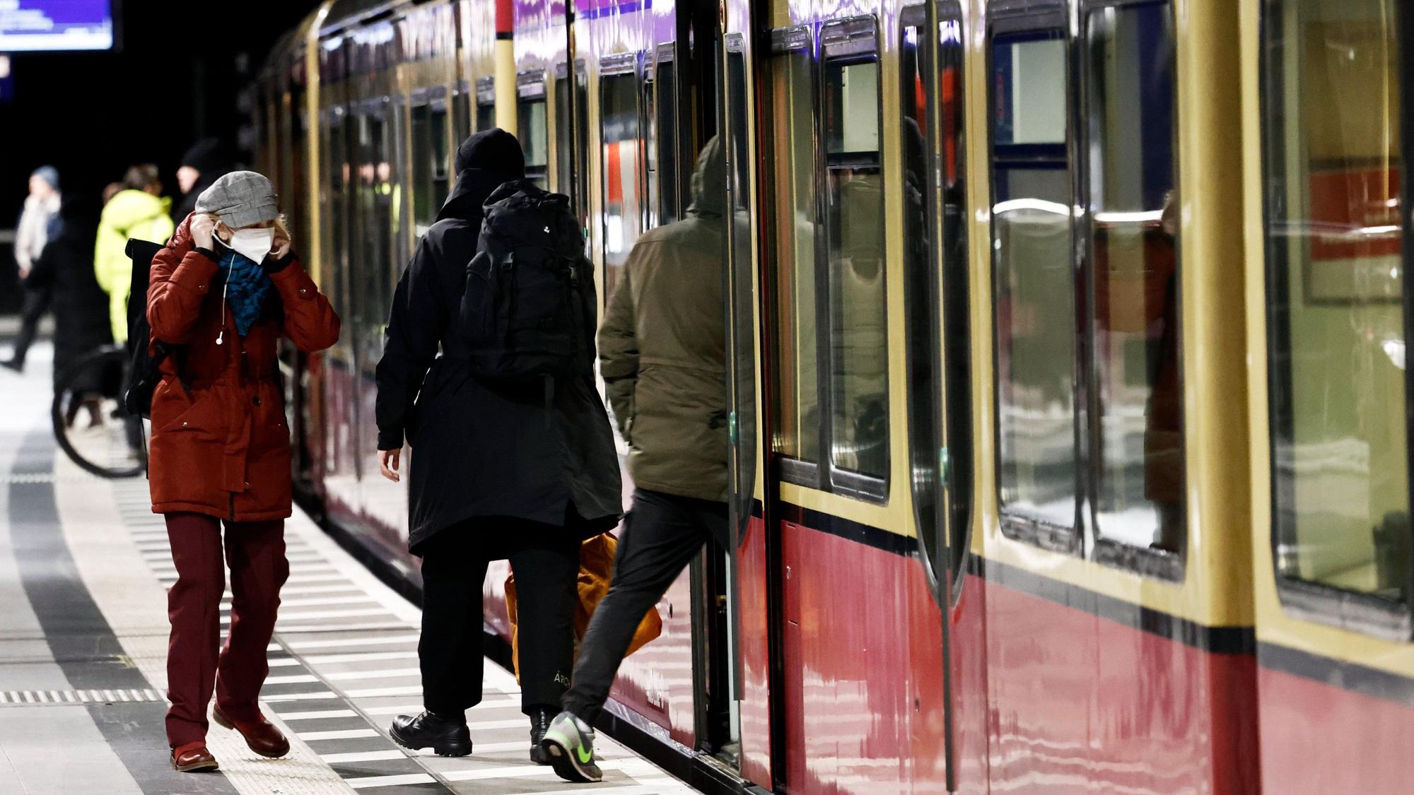 Fahrgäste betreten auf einem Bahnsteig eine S-Bahn.