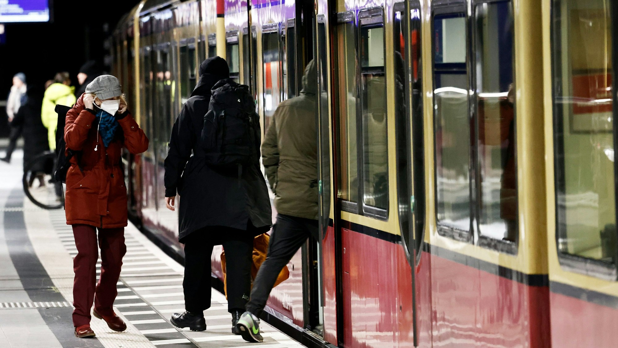 Fahrgäste betreten auf einem Bahnsteig eine S-Bahn.