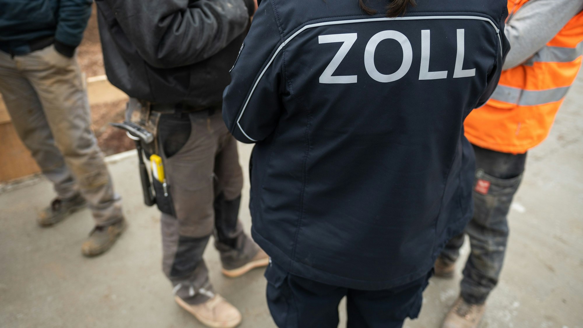Mitarbeiter des Zolls führen eine Kontrolle auf einer Baustelle durch.