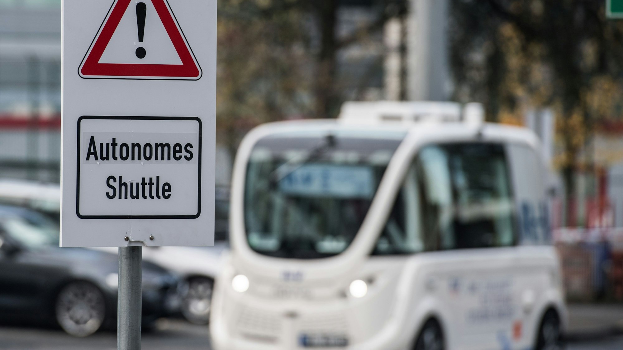 Ein Schild „Autonomes Shuttle“ weist auf dem Flughafen in Frankfurt am Main (Hessen) auf den Testbetrieb hin. Der Flughafenbetreiber Fraport testet selbstfahrende Shuttles auf dem Flughafen-Betriebsgelände.