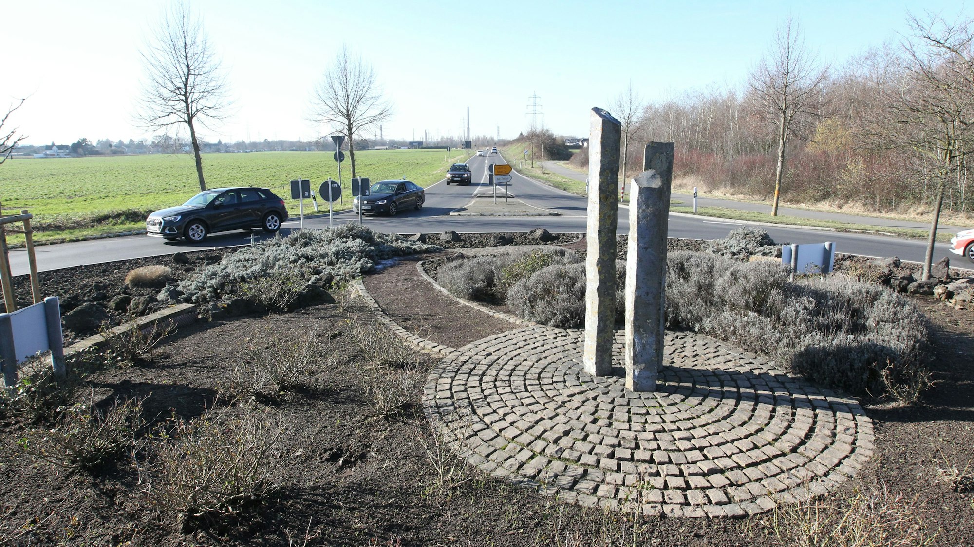 Zwei Straßenschilder an einem Kreisverkehr zeigen in Richtung Lülsdorf, Ranzel und Niederkassel-Zentrum.