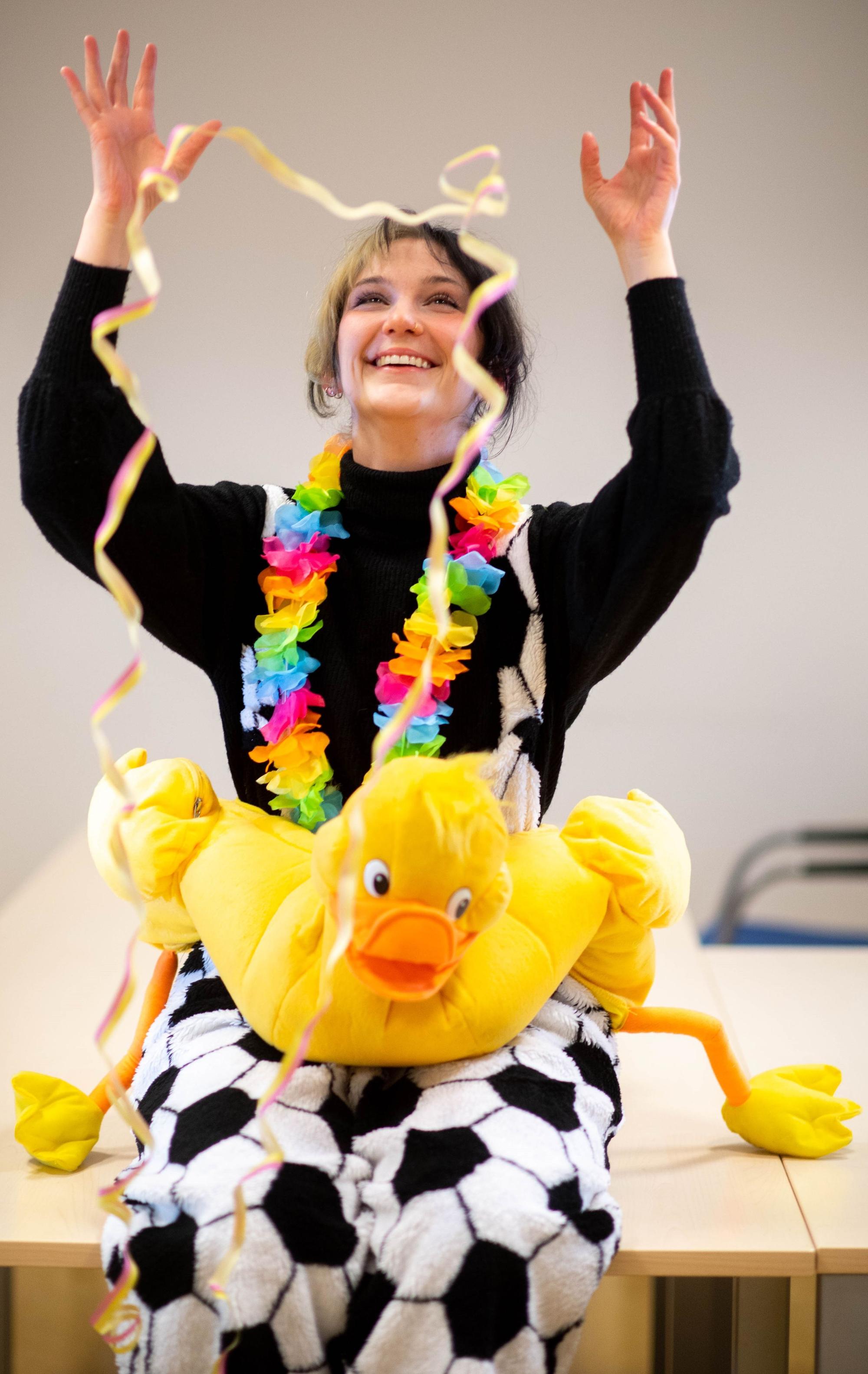 Voluntärin Elena Pintus sitzt jeck verkleidet auf einem Tisch