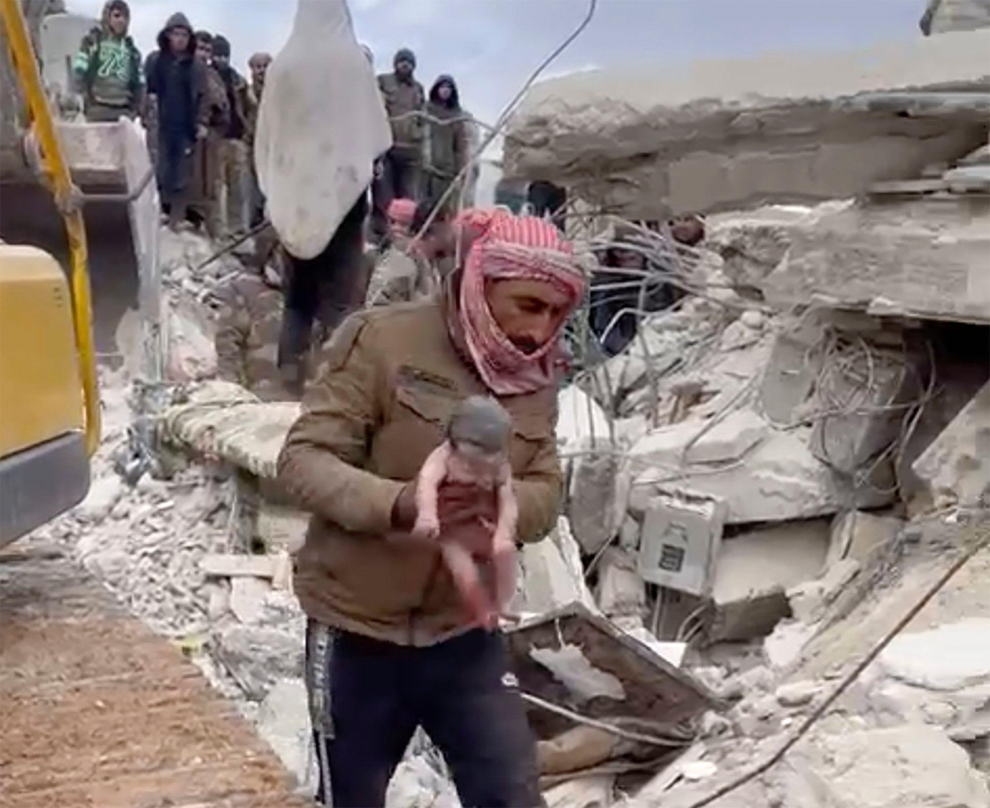 08.02.2023, Syrien, Jinderis: Ein Retter trägt ein neugeborenes Mädchen, nachdem er es aus Trümmern befreit hat. Bewohner der nordwestsyrischen Stadt entdeckten das schreiende Kind, dessen Mutter es unter den Trümmern eines fünfstöckigen Wohnhauses, das durch das verheerende Erdbeben zerstört wurde, geboren hatte, wie Verwandte und ein Arzt berichten (bestmögliche Qualität). Foto: Uncredited/Verified UGC/AP/dpa +++ dpa-Bildfunk +++