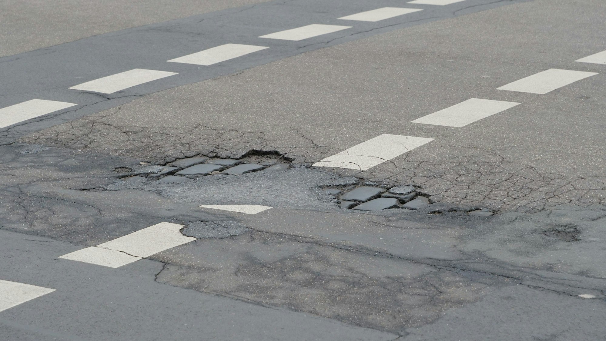 Auf der Berrenrather Straße sind Schlaglöcher zu sehen.