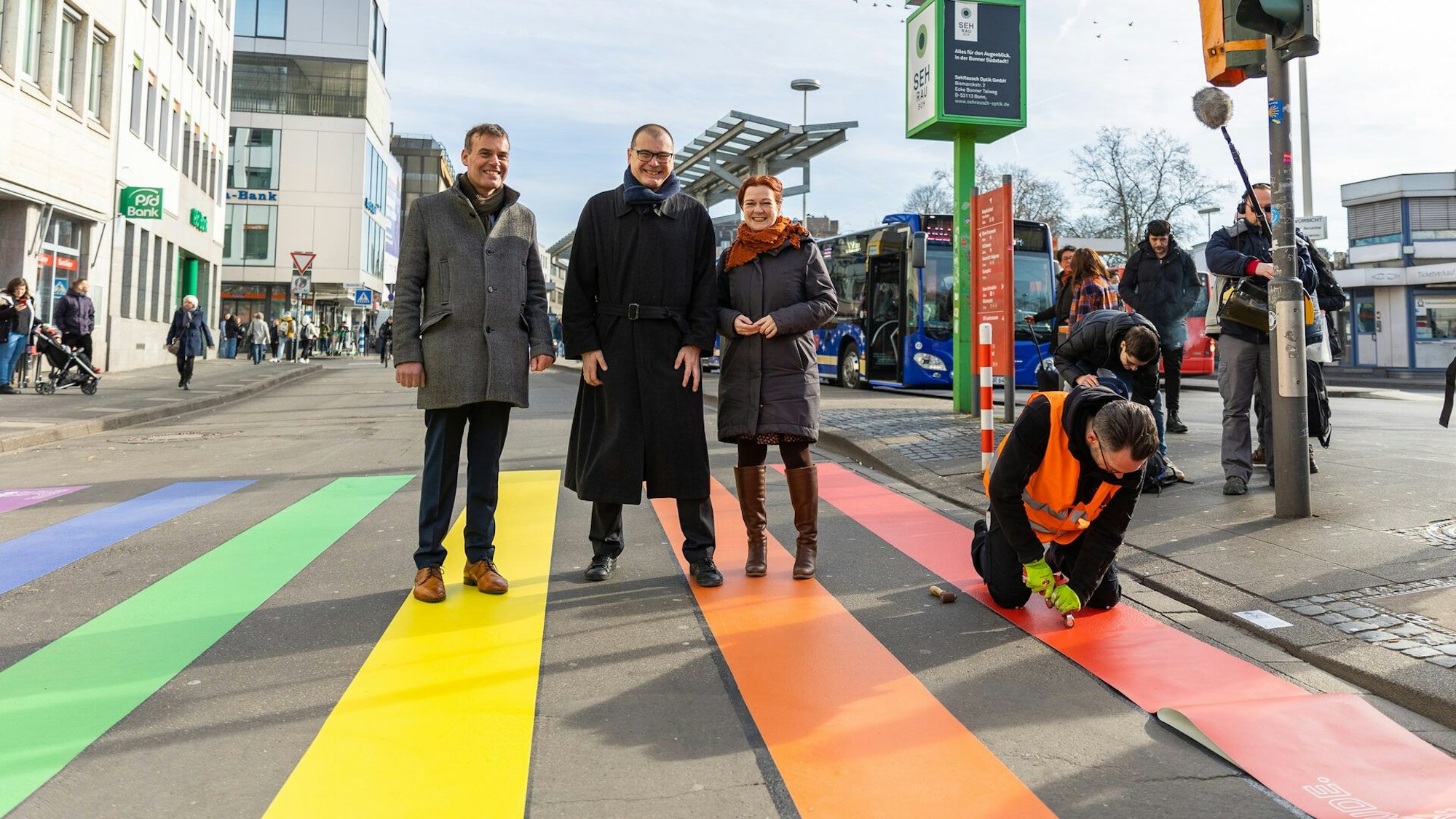 Zu sehen ist ein Straßenübergang in Bonn. Die Zebrastreifen sind regenbogenfarben.