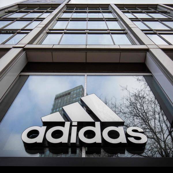Das Adidas-Logo am Eingang eines Geschäfts.