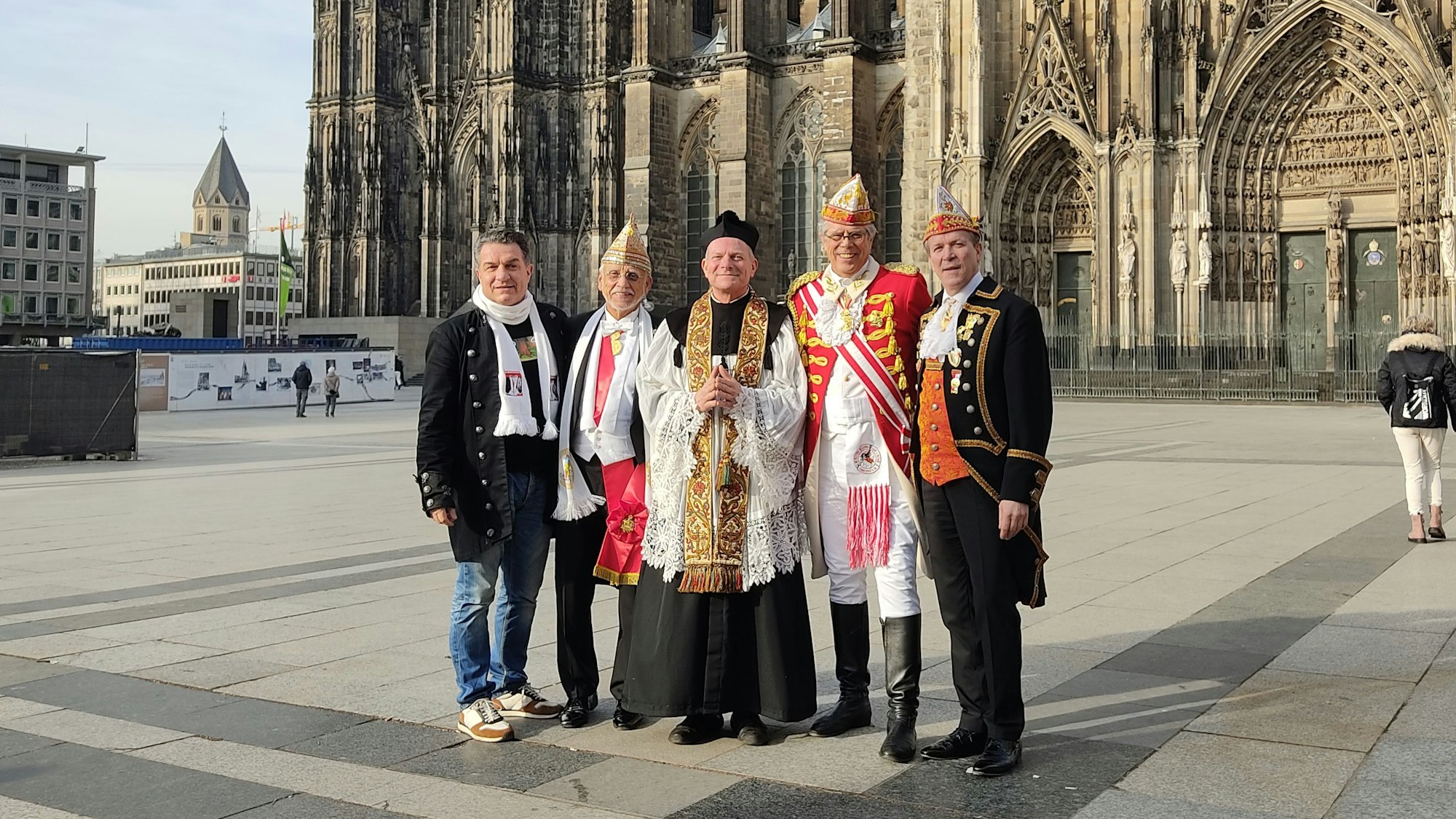 Vor dem Kölner Dom stehen Moderator Linus, Dr. Joachim Zöller, „Nubbel“ Mike Hehn, Heinz-Günther Hunold, und Christoph Kuckelkorn und posieren auf der Pressekonferenz für die Nubbelverbrennung am Dom.
