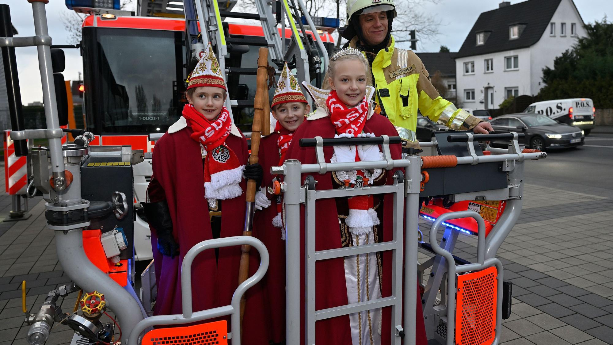 Bergish Gladbachs Kinderdreigestirn steht im Korb einer Feuerwehrdrehleiter.