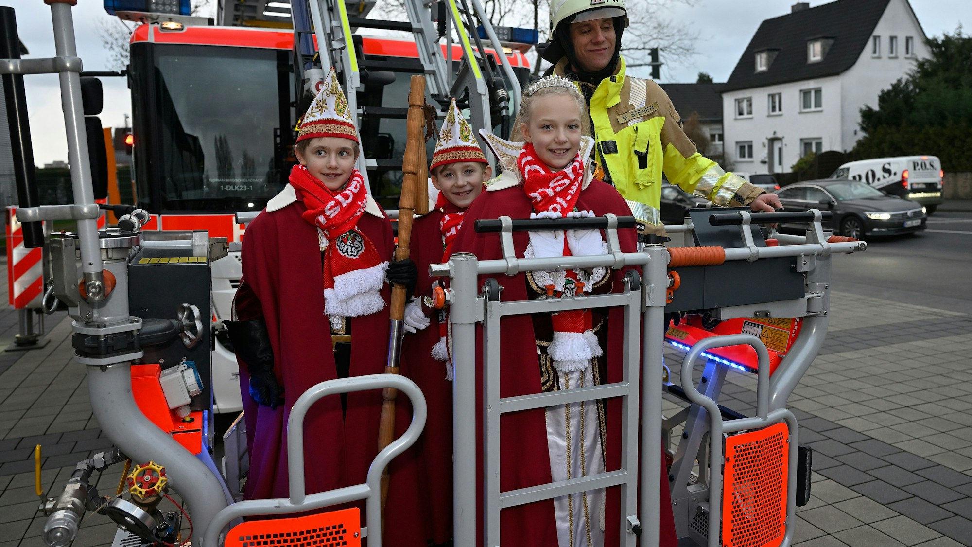 Bergish Gladbachs Kinderdreigestirn steht im Korb einer Feuerwehrdrehleiter.